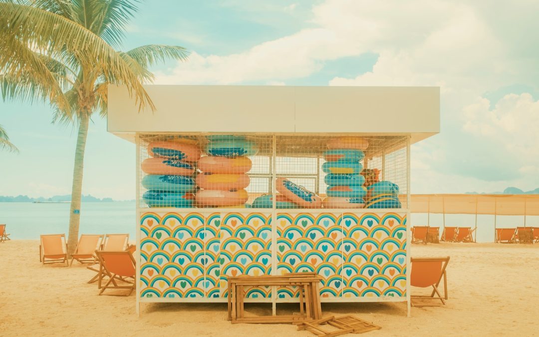 a small stand on a beach with chairs and a table